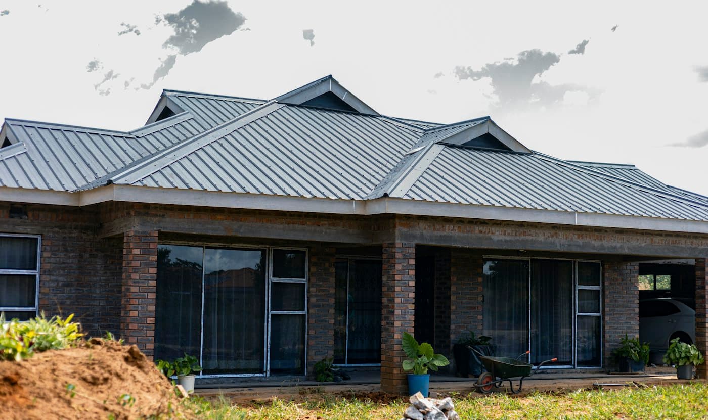 A finished brick bungalow with a grey metal roof