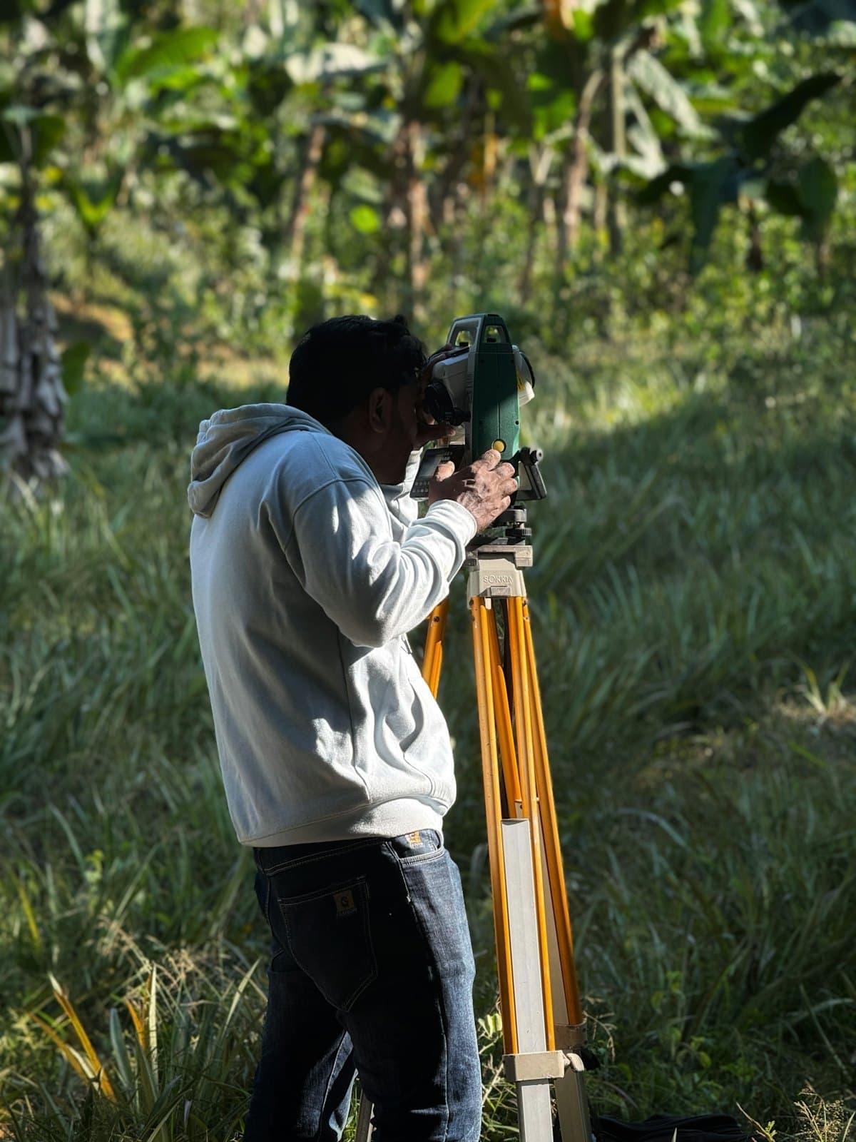 A surveyor looking through a total station on a tripod