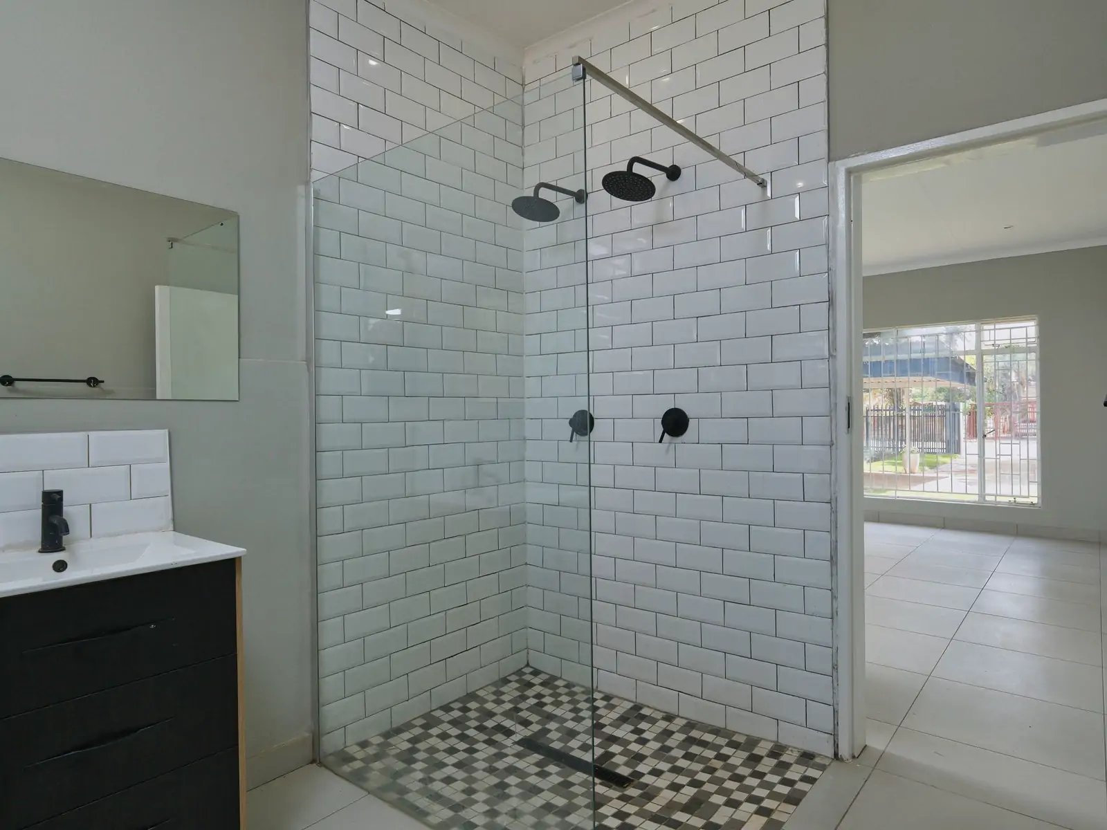 Bathroom 2: wide photo from the doorway. A walk-in shower with white wall tiles and a glass screen, a basin cabinet and the door open to the next room (sample photo)