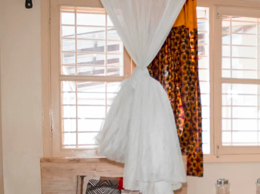 Bedroom 2: windows and doors. The window in its frame, with the mosquito net tied up beside it (sample photo)