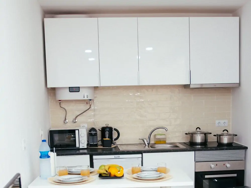Kitchen: the ceiling. The white wall cupboards and the water heater above the counter (sample photo)