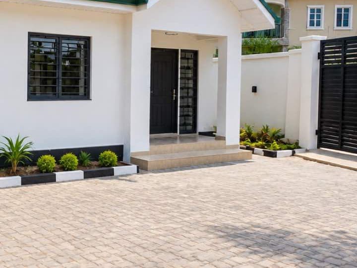 Outside: the compound. The front porch, the paved yard and the black sliding gate (sample image)